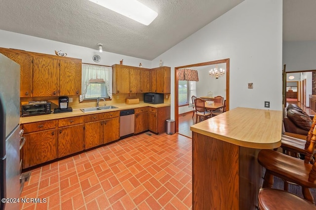 kitchen with stainless steel appliances, brown cabinets, light countertops, and a sink