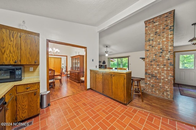 kitchen with black appliances, brown cabinetry, brick floor, and light countertops