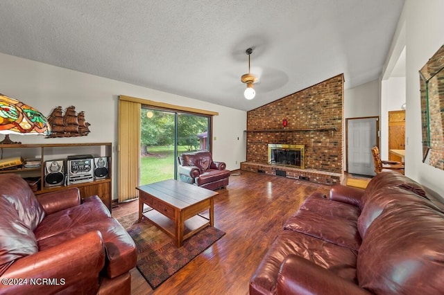 living room with lofted ceiling, a fireplace, a textured ceiling, and wood finished floors