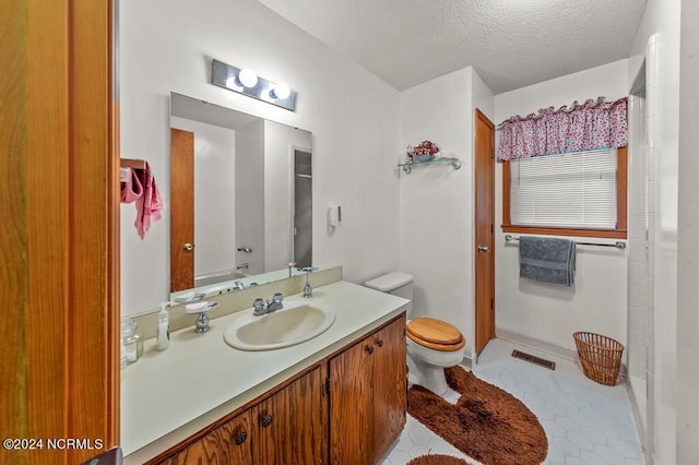 bathroom featuring visible vents, toilet, a textured ceiling, vanity, and tile patterned flooring