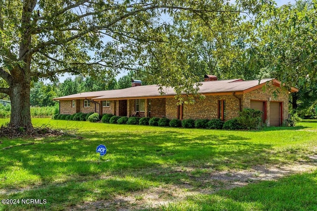 single story home featuring brick siding, a front lawn, and an attached garage