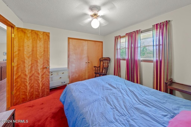 bedroom with a closet, carpet flooring, ceiling fan, and a textured ceiling