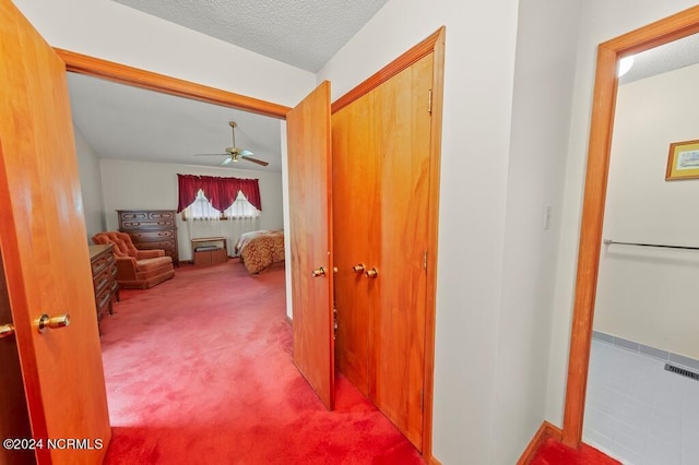 corridor featuring carpet floors and a textured ceiling