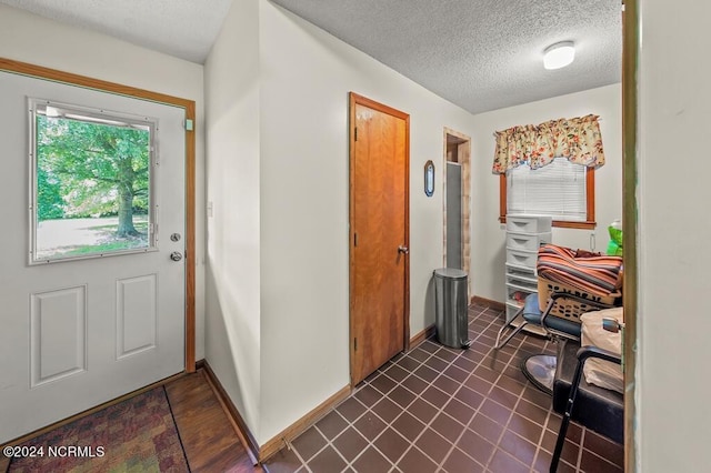 foyer entrance with baseboards and a textured ceiling