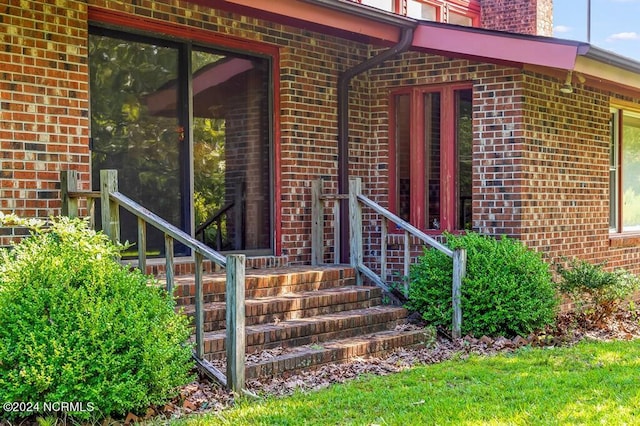 doorway to property with brick siding