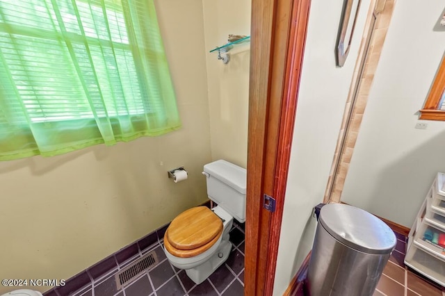 bathroom with tile patterned flooring, visible vents, and toilet