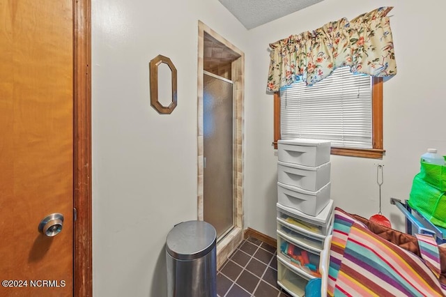 bathroom featuring a stall shower, tile patterned flooring, and a textured ceiling