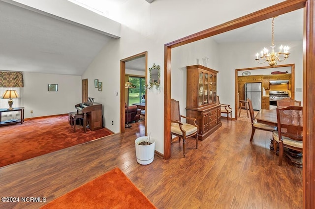 interior space featuring a chandelier, vaulted ceiling, baseboards, and wood finished floors