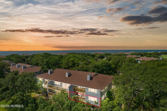 aerial view at dusk featuring a water view