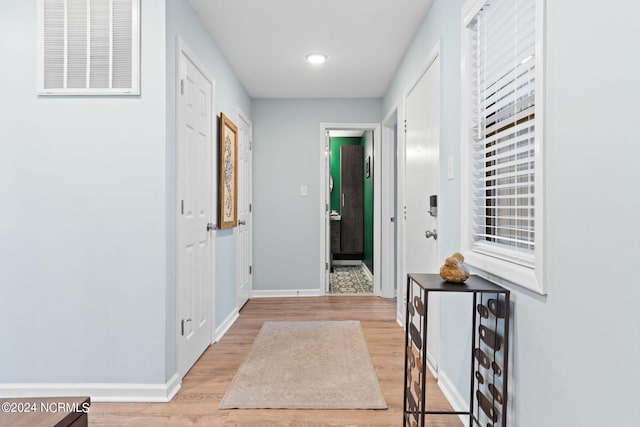 interior space featuring baseboards, visible vents, and light wood finished floors