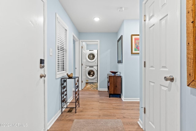 corridor with stacked washer and dryer and light wood-type flooring