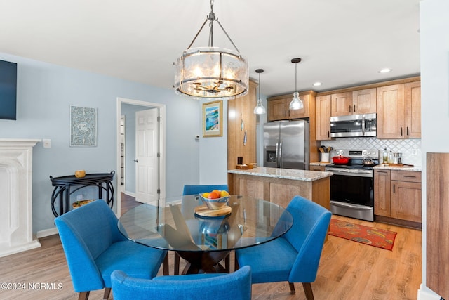 dining area with light hardwood / wood-style flooring and a chandelier