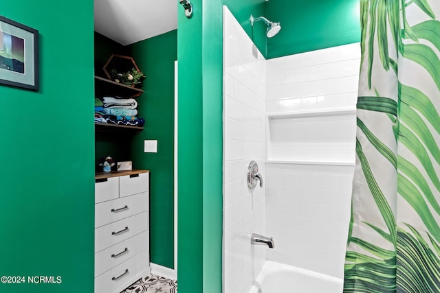 bathroom featuring shower / bath combo and baseboards