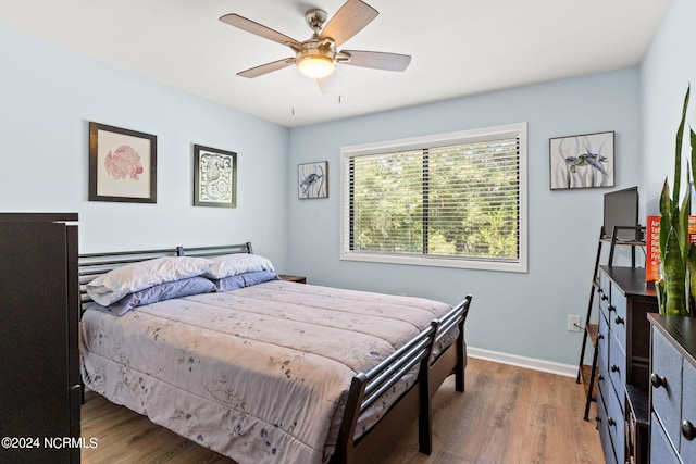 bedroom with wood finished floors, a ceiling fan, and baseboards