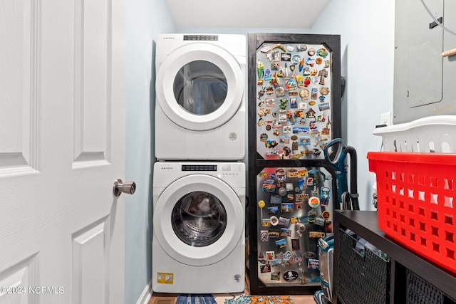 clothes washing area with stacked washer / dryer and laundry area