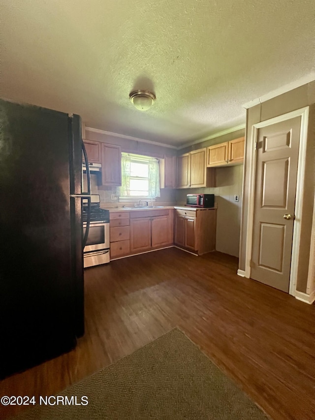 kitchen featuring dark wood-type flooring, sink, gas stove, black fridge, and light brown cabinets