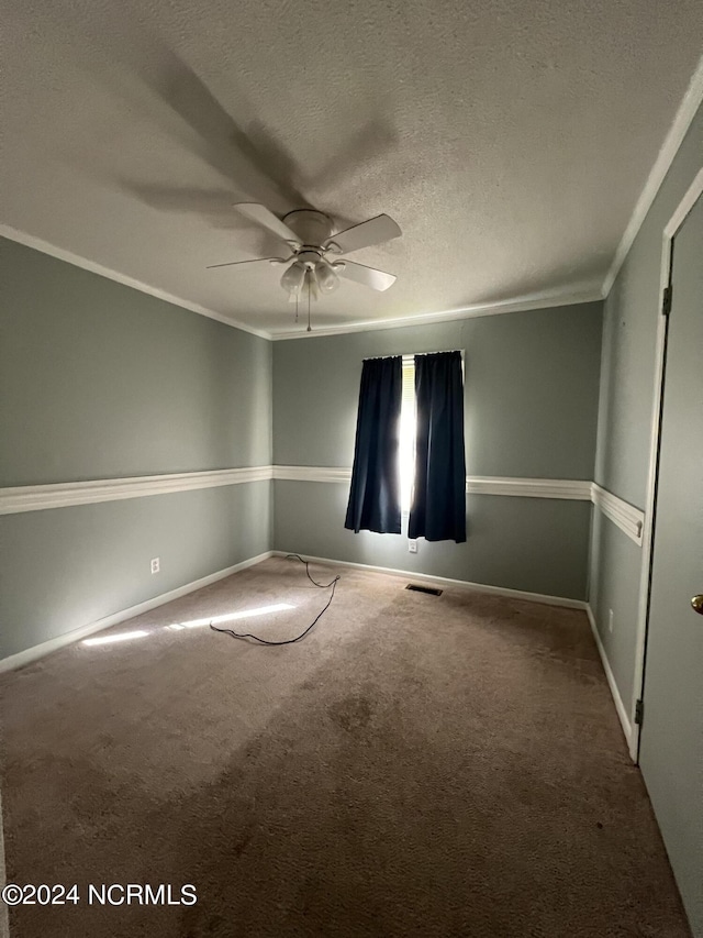 carpeted empty room featuring a textured ceiling, ornamental molding, and ceiling fan