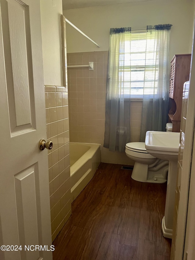 bathroom featuring toilet, wood-type flooring, and bathtub / shower combination