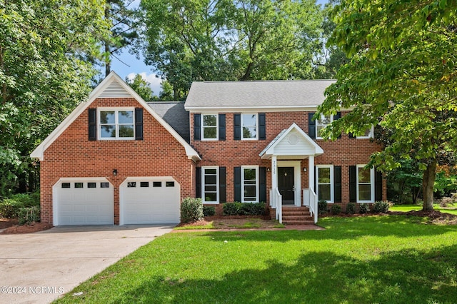 colonial-style house featuring a garage and a front yard