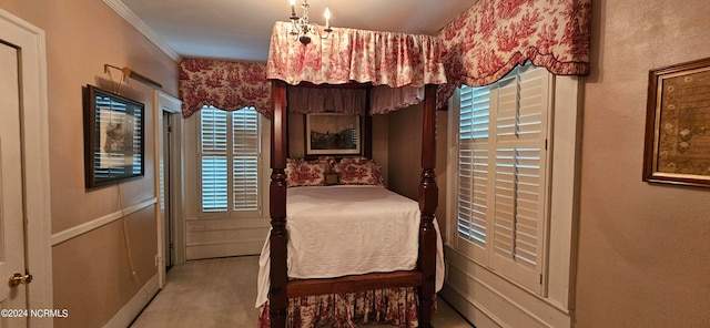 carpeted bedroom with a chandelier and crown molding