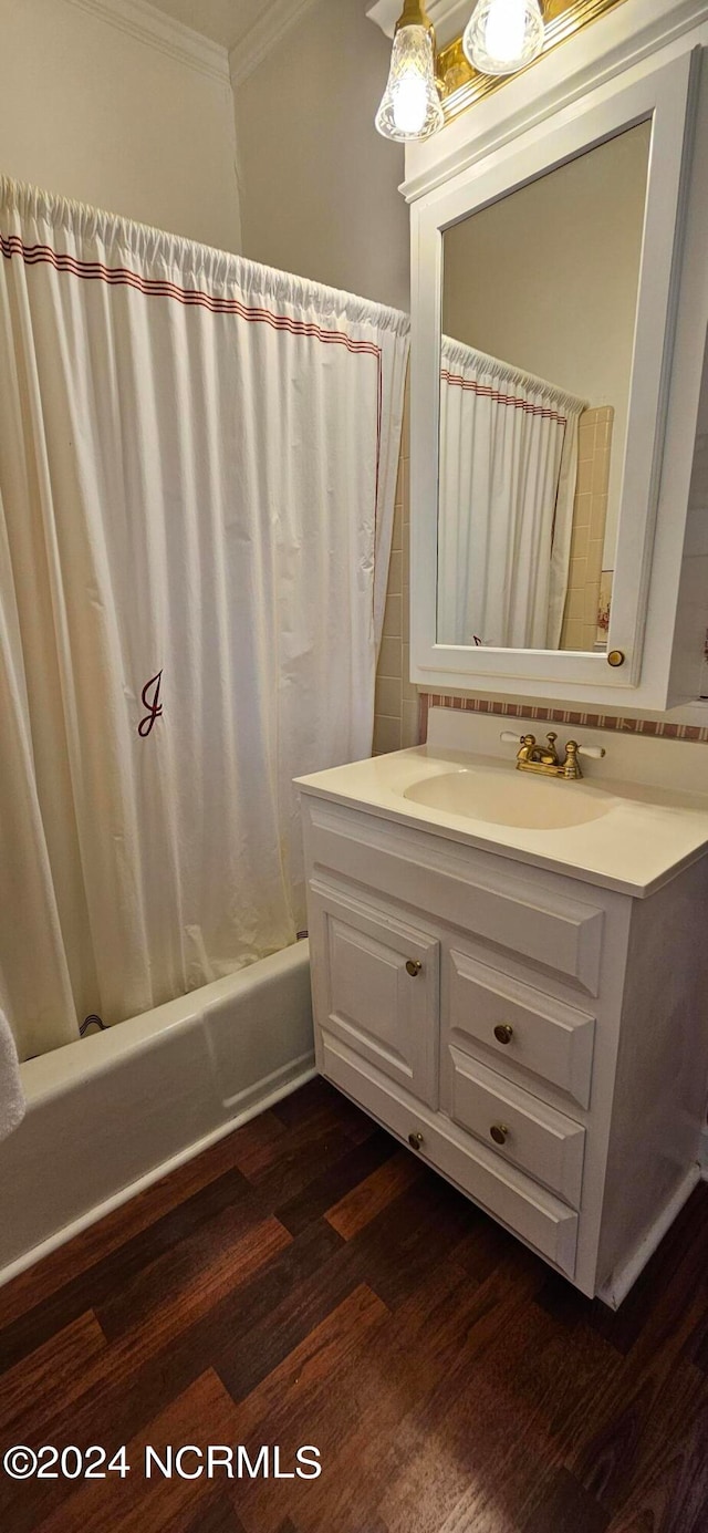 bathroom featuring vanity, hardwood / wood-style flooring, shower / tub combo, and ornamental molding