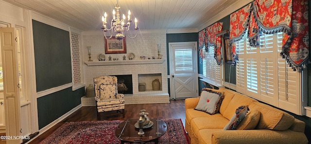 living room with dark wood-type flooring, a notable chandelier, a fireplace, crown molding, and wooden ceiling