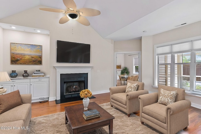 living room featuring high vaulted ceiling, light wood-type flooring, and ceiling fan