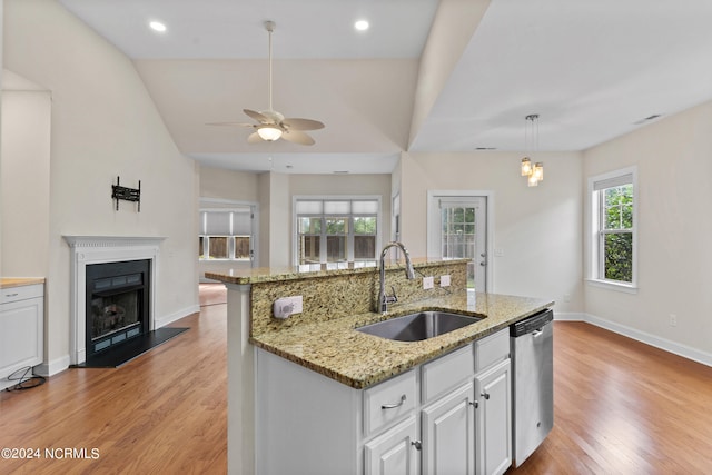 kitchen featuring plenty of natural light, sink, stainless steel dishwasher, and white cabinets