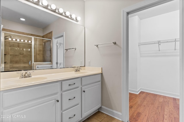 bathroom with a shower with door, vanity, and hardwood / wood-style floors