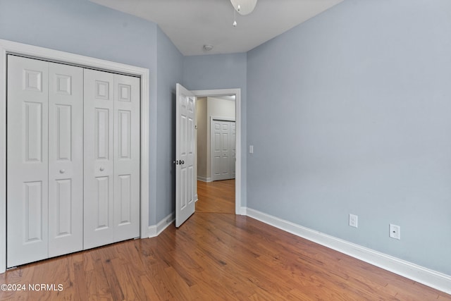 unfurnished bedroom featuring a closet and hardwood / wood-style floors