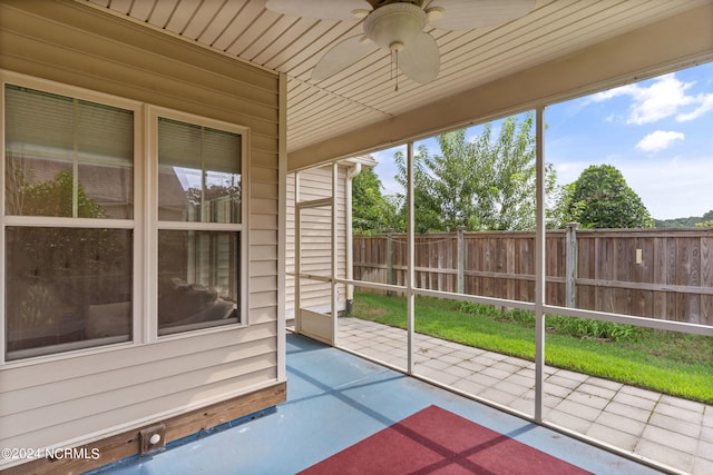 unfurnished sunroom featuring ceiling fan