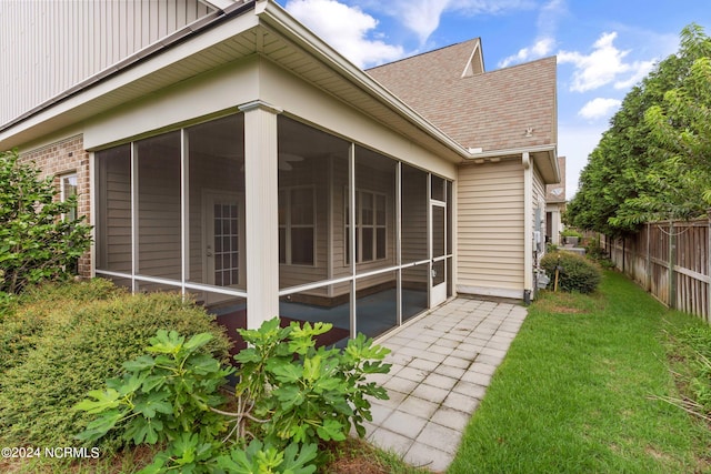 rear view of house with a sunroom and a lawn