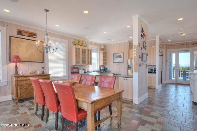 dining space with plenty of natural light, ceiling fan with notable chandelier, and tile patterned floors