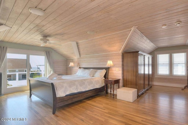 bedroom with ceiling fan, wooden ceiling, vaulted ceiling, wood walls, and light hardwood / wood-style flooring