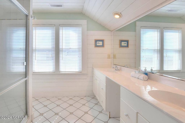 bathroom featuring walk in shower, lofted ceiling, dual vanity, and tile patterned floors