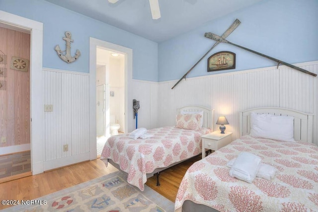 bedroom with wood-type flooring, ensuite bathroom, and ceiling fan