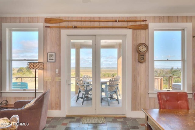 entryway with wood walls and dark tile patterned floors