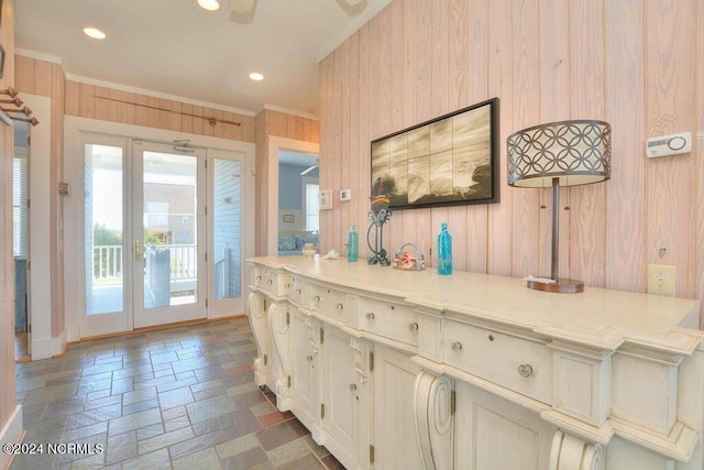 corridor featuring a wealth of natural light, crown molding, and wooden walls