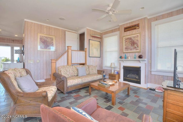 living room featuring crown molding, wooden walls, dark tile patterned flooring, and ceiling fan