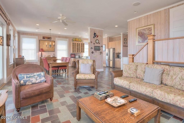 living room with crown molding, dark tile patterned flooring, and ceiling fan