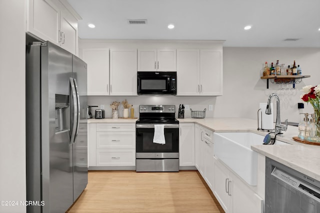 kitchen featuring light hardwood / wood-style flooring, stainless steel appliances, white cabinetry, and light stone countertops