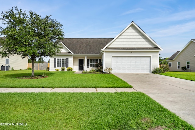 view of front of home featuring cooling unit, a garage, and a front lawn