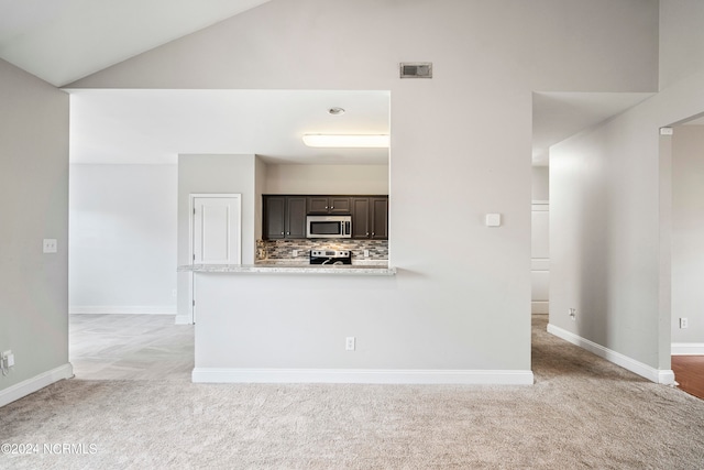 kitchen with backsplash, light carpet, appliances with stainless steel finishes, and kitchen peninsula