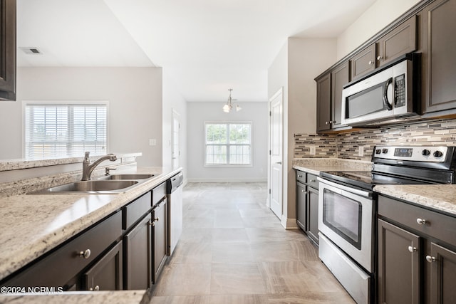 kitchen with stainless steel appliances, sink, dark brown cabinets, decorative backsplash, and light tile patterned flooring