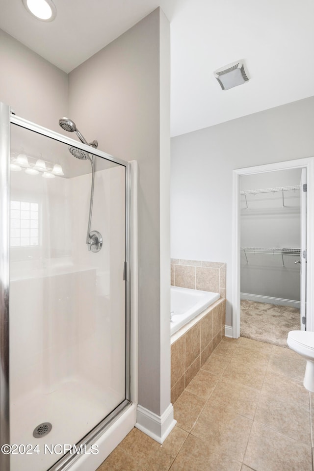 bathroom featuring shower with separate bathtub, tile patterned floors, and toilet