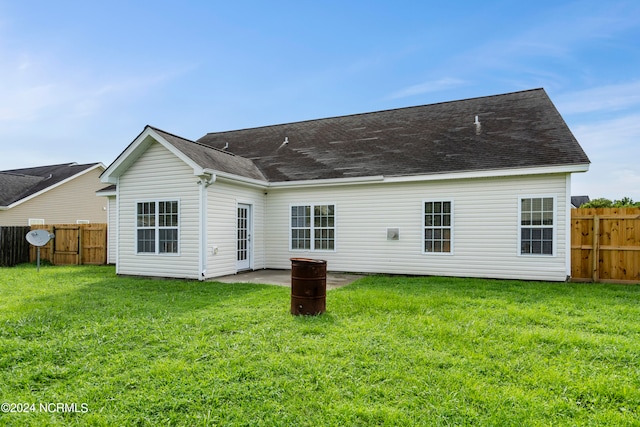 back of house with a patio and a yard