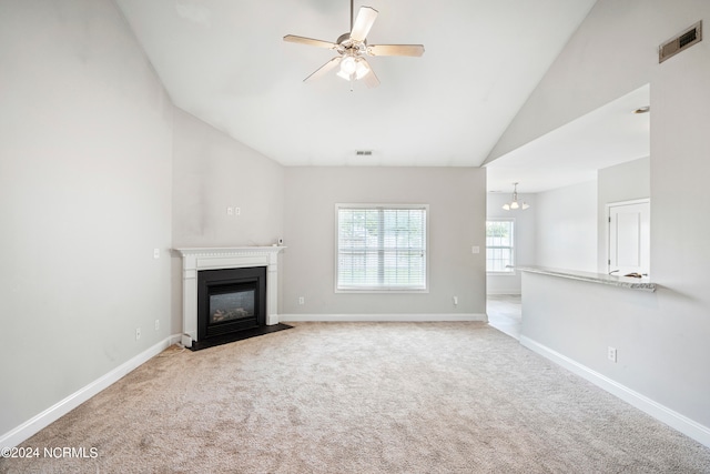 unfurnished living room with light carpet, ceiling fan, and high vaulted ceiling