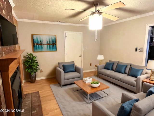 living room featuring light wood-type flooring, ceiling fan, and a textured ceiling