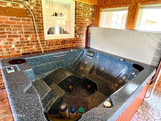 room details with a tub, a hot tub, and hardwood / wood-style flooring