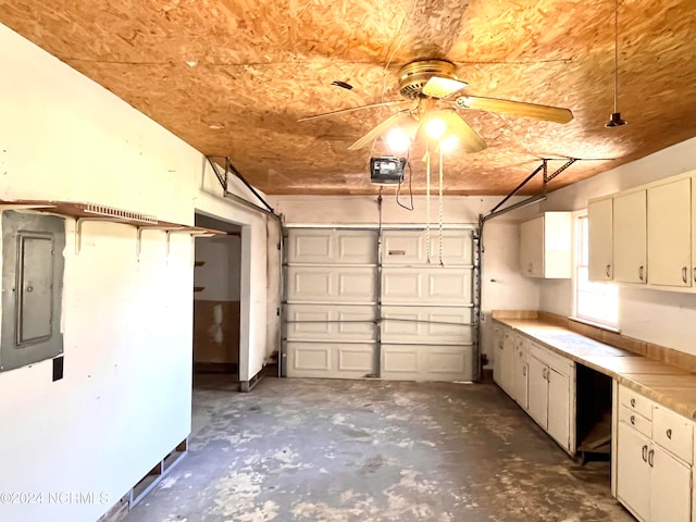 garage featuring a garage door opener, electric panel, and ceiling fan